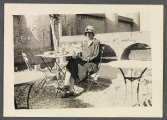 Eugénie and Charles Prendergast 1927 tour of France and Monaco; Eugénie Prendergast seated at outdoor table in Carcassone