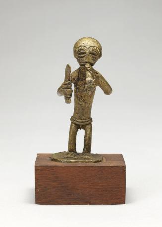 Gold weight in the form of a man holding a sword and smoking