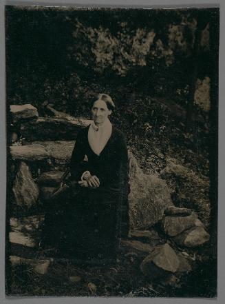 Portrait of a woman sitting in a rocky landscape