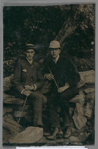 Portrait of two young men sitting in a rocky landscape