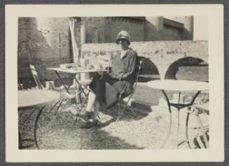 Eugénie and Charles Prendergast 1927 tour of France and Monaco; Eugénie Prendergast seated at outdoor table in Carcassone