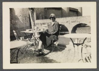 Eugénie and Charles Prendergast 1927 tour of France and Monaco; Eugénie Prendergast seated at outdoor table in Carcassone