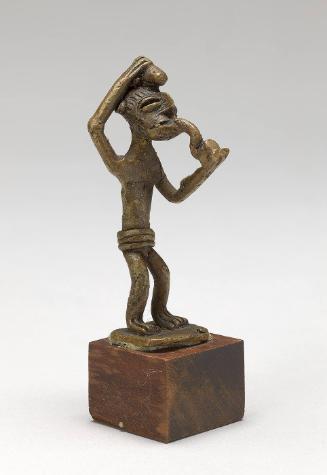Gold weight in the form of a man smoking a pipe and carrying gunpowder