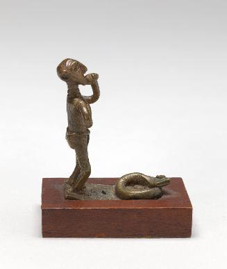 Gold weight in the form of a man standing before snakes